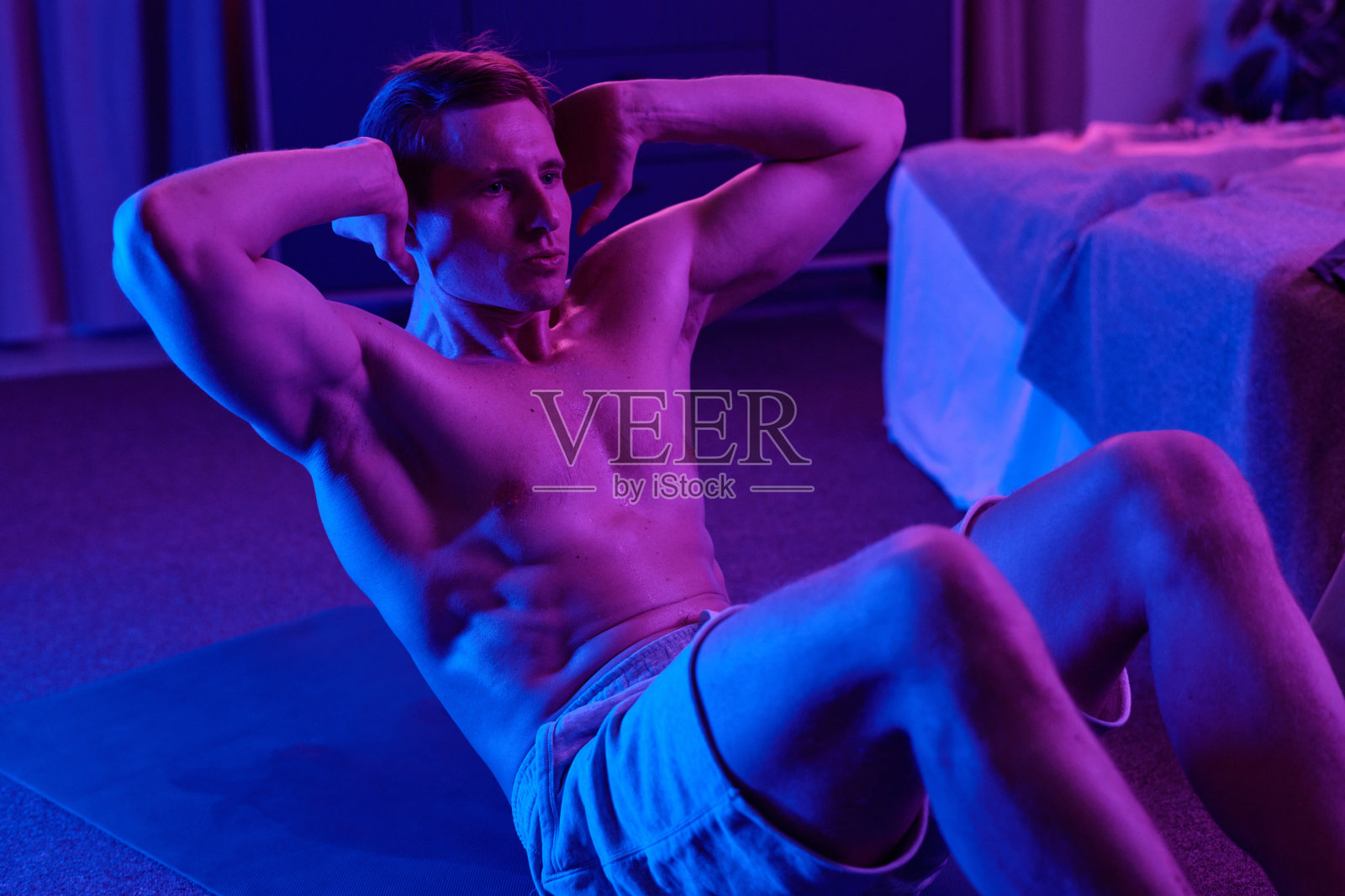 男人在室内进行仰卧起坐锻炼核心肌肉照片摄影图片