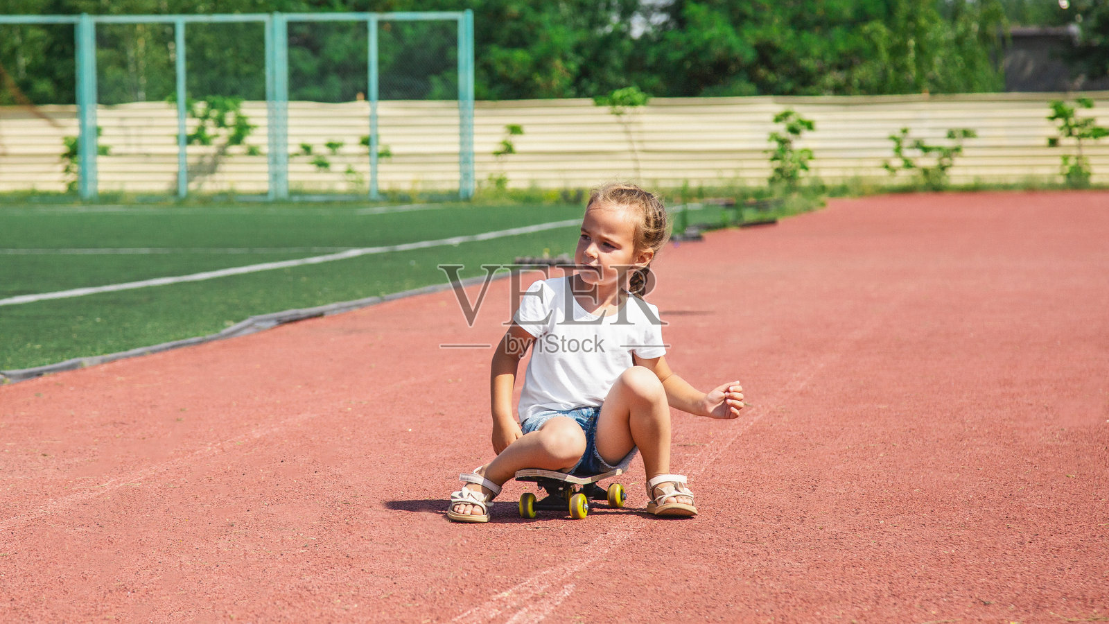 4-5岁的女孩在街上玩滑板，童年，夏日。照片摄影图片