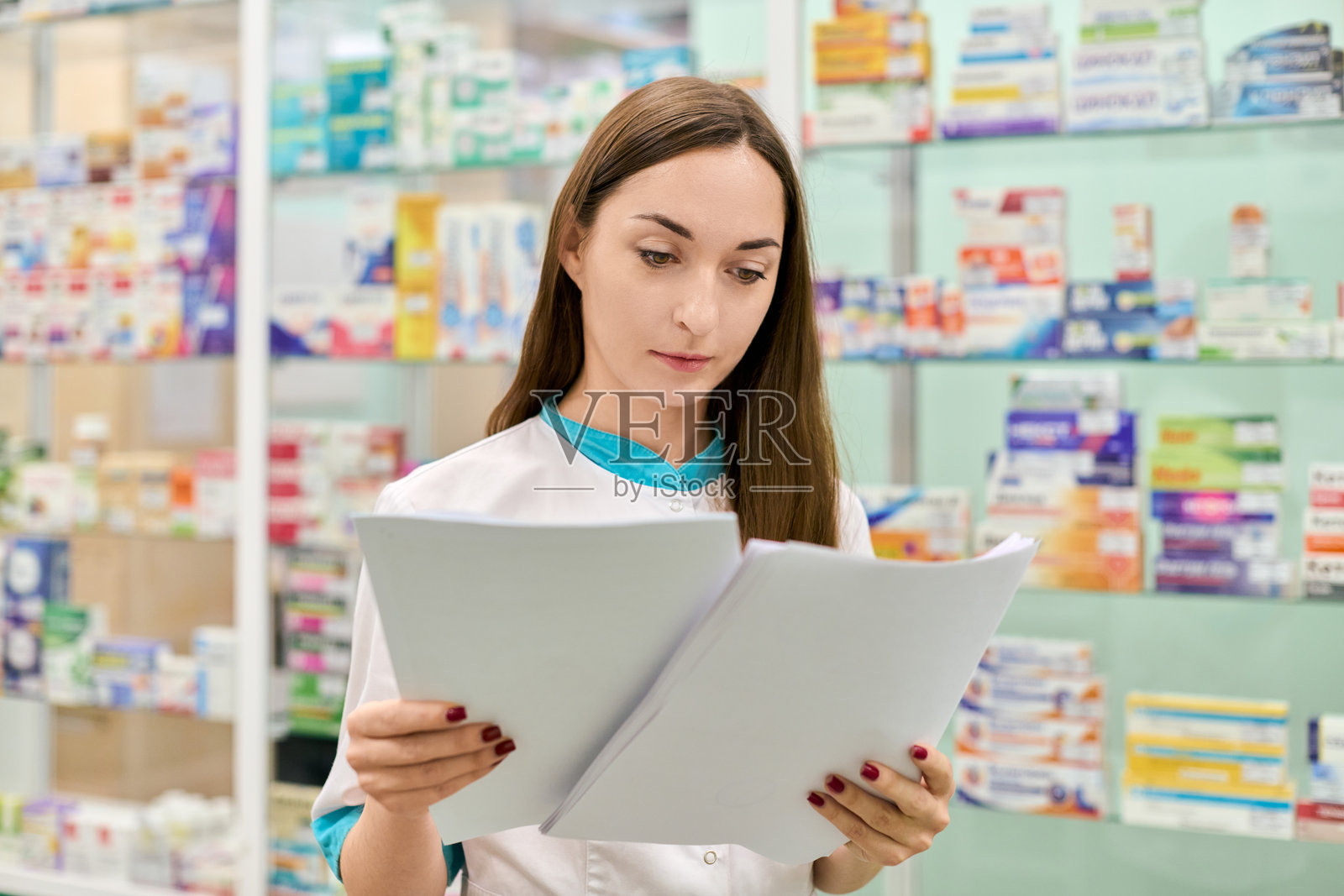 年轻的女药剂师在药房审阅文件照片摄影图片