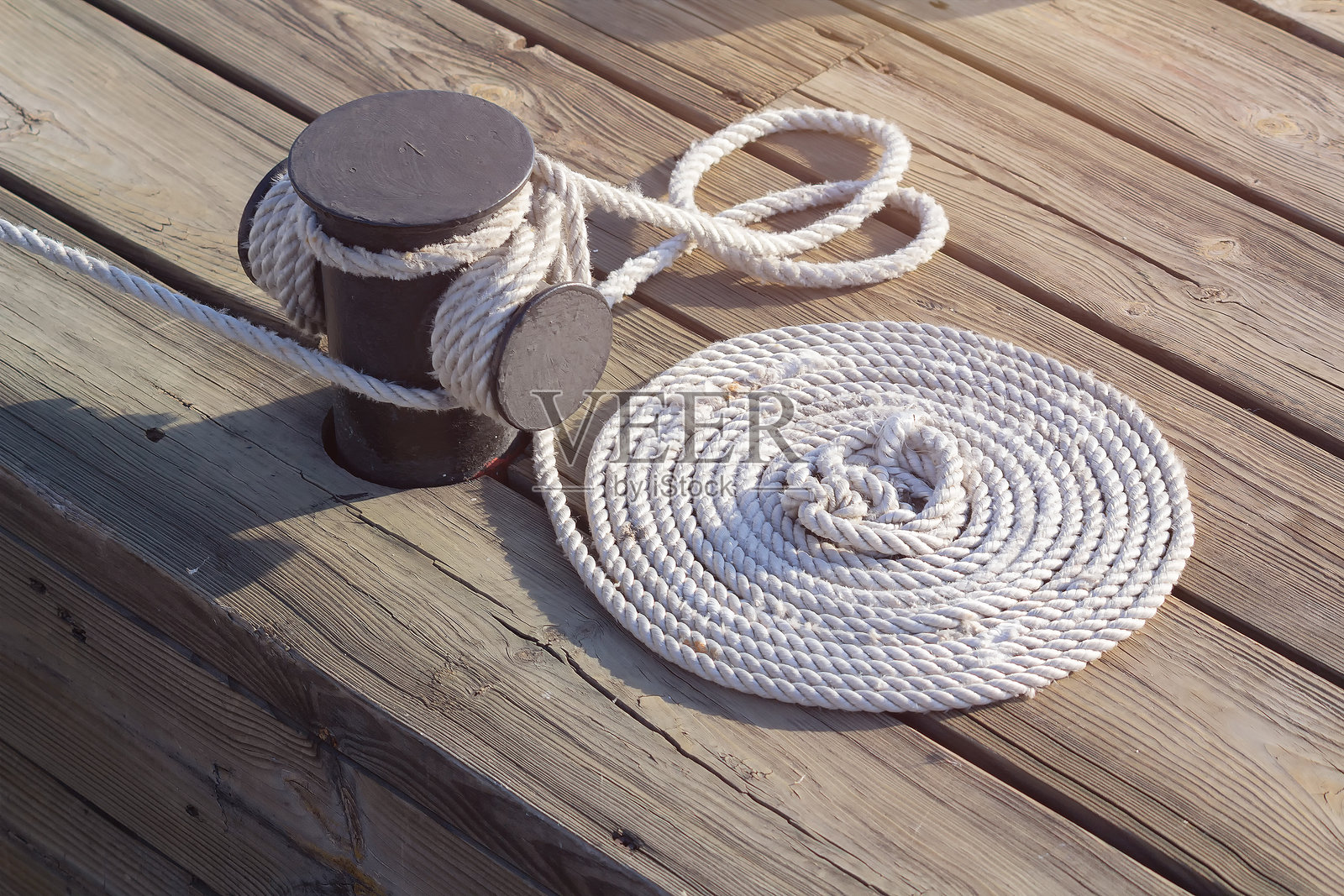 系在木码头上的带绳结的系泊绳照片摄影图片