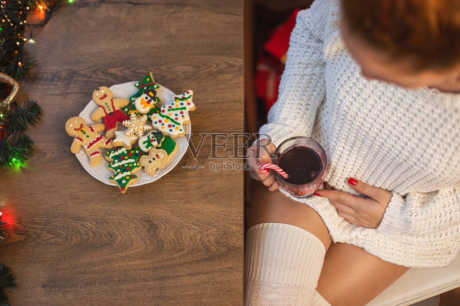 年轻女子在圣诞假期期间喝热巧克力吃拐杖糖照片摄影图片