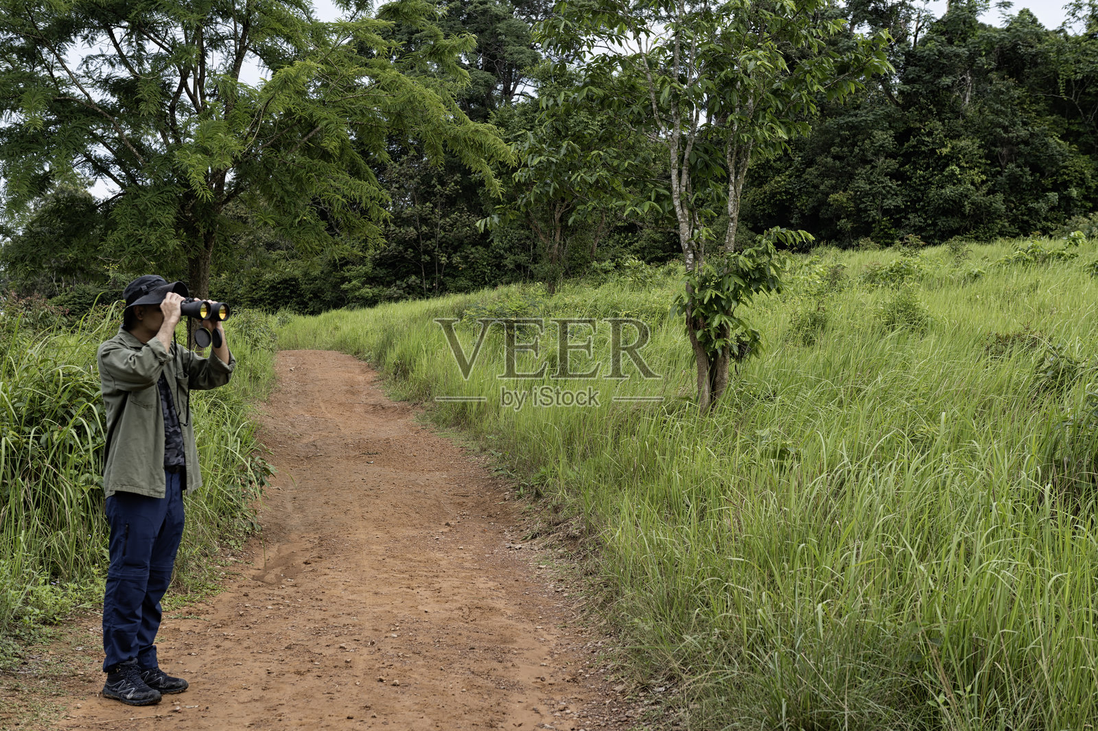 男人在草原上用望远镜观鸟照片摄影图片