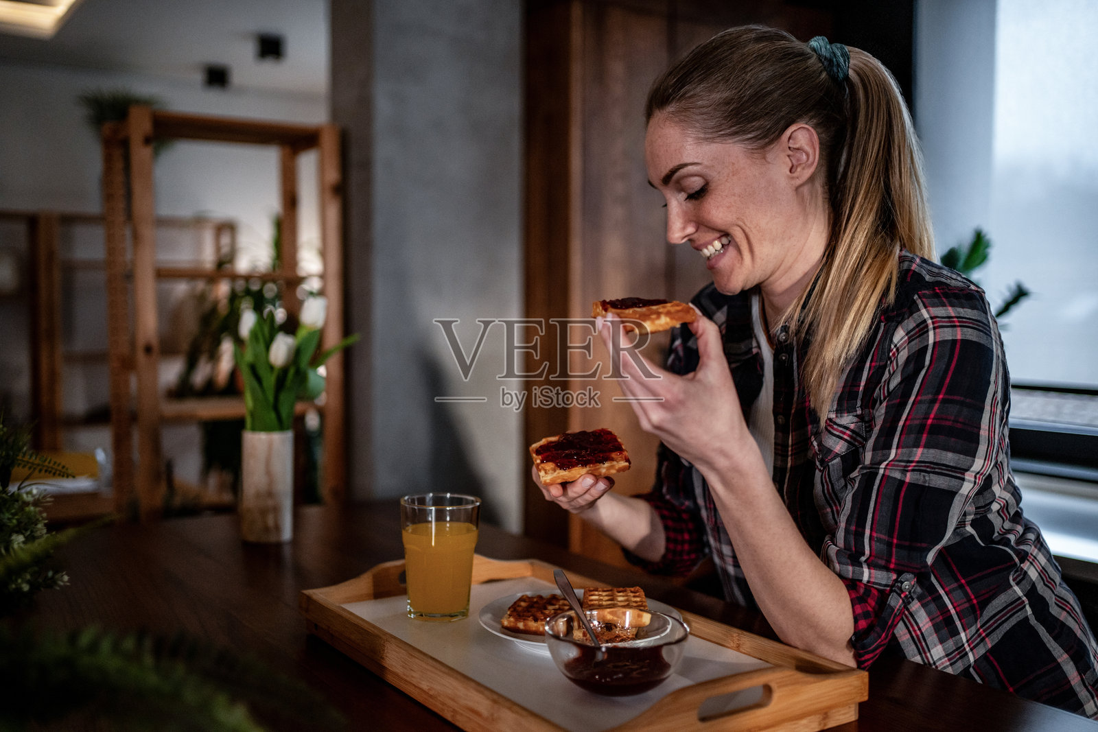 年轻女子享用美味的早餐华夫饼，配有果酱和果汁照片摄影图片