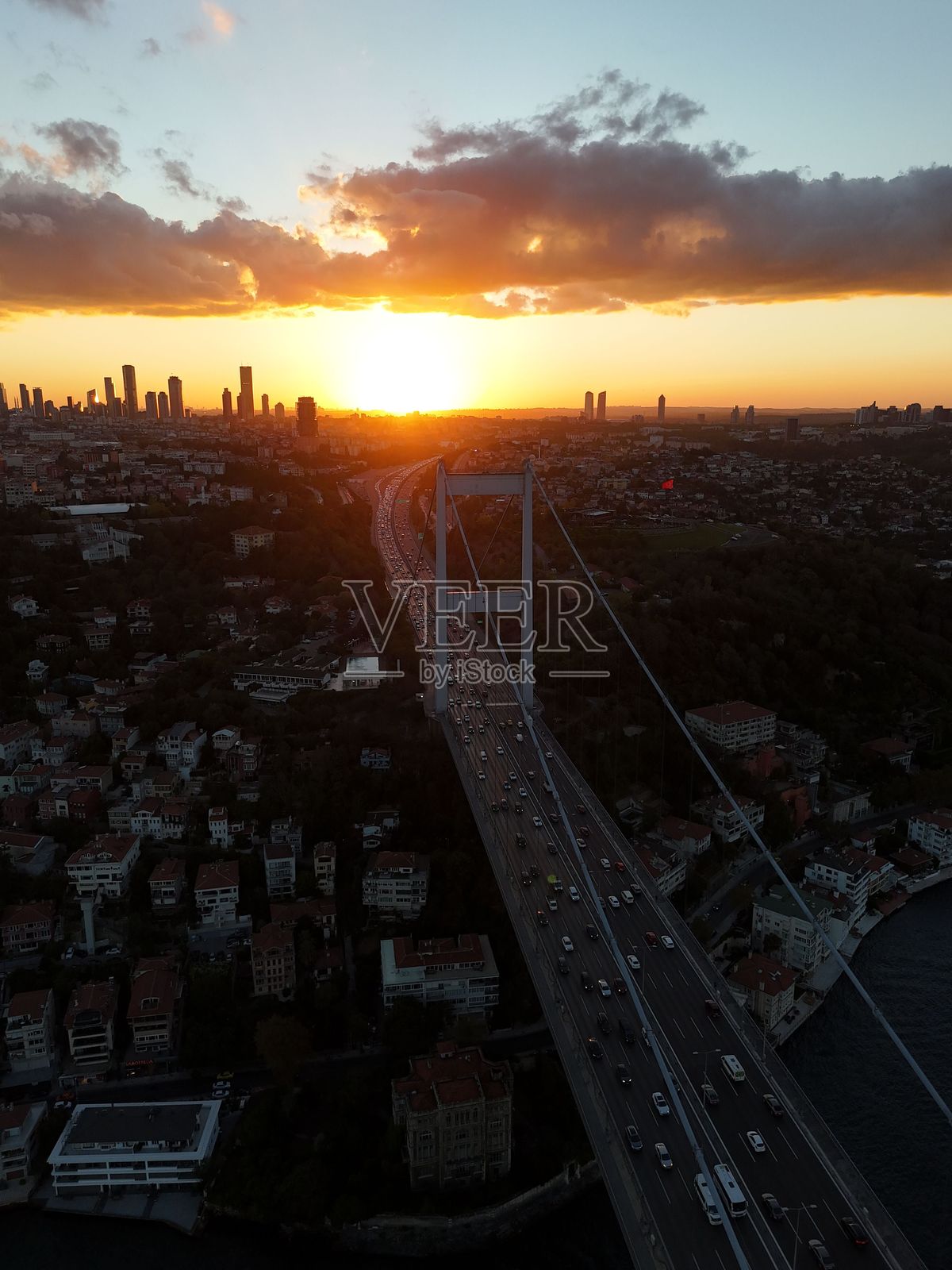 日落时分伊斯坦布尔博斯普鲁斯大桥的鸟瞰图，展现了城市天际线和绚丽的天空。照片摄影图片