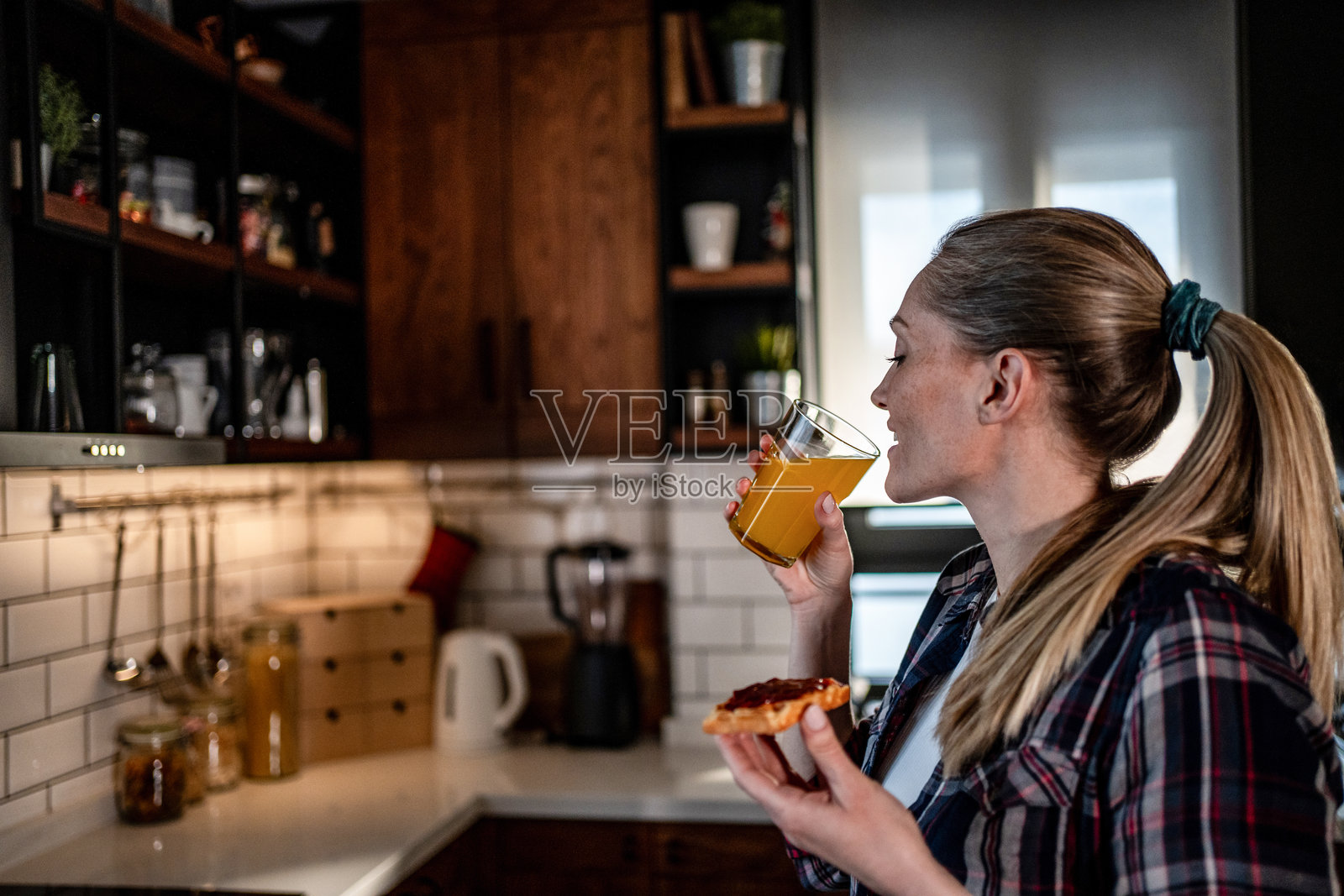 女子享用健康的早餐，配有橙汁和吐司照片摄影图片