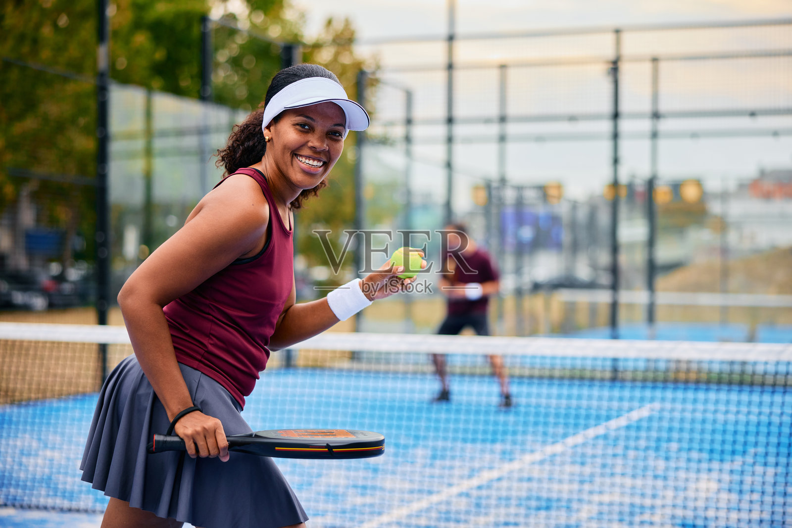 一名女子在球场上拿着网球拍微笑照片摄影图片