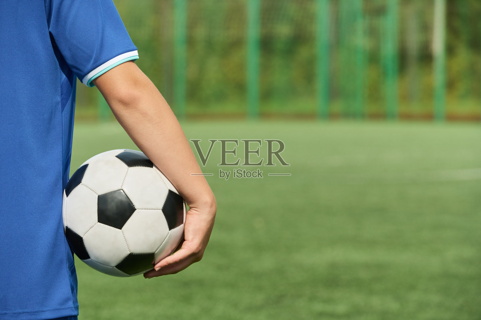 比赛前在户外球场拿着足球的少年照片摄影图片