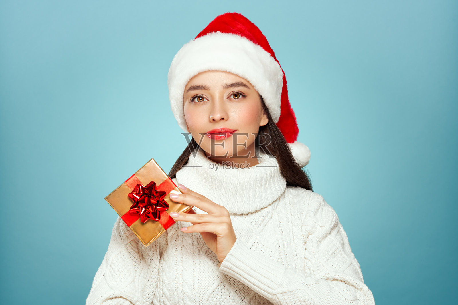 身穿白色针织毛衣的美丽女子手持礼品盒照片摄影图片