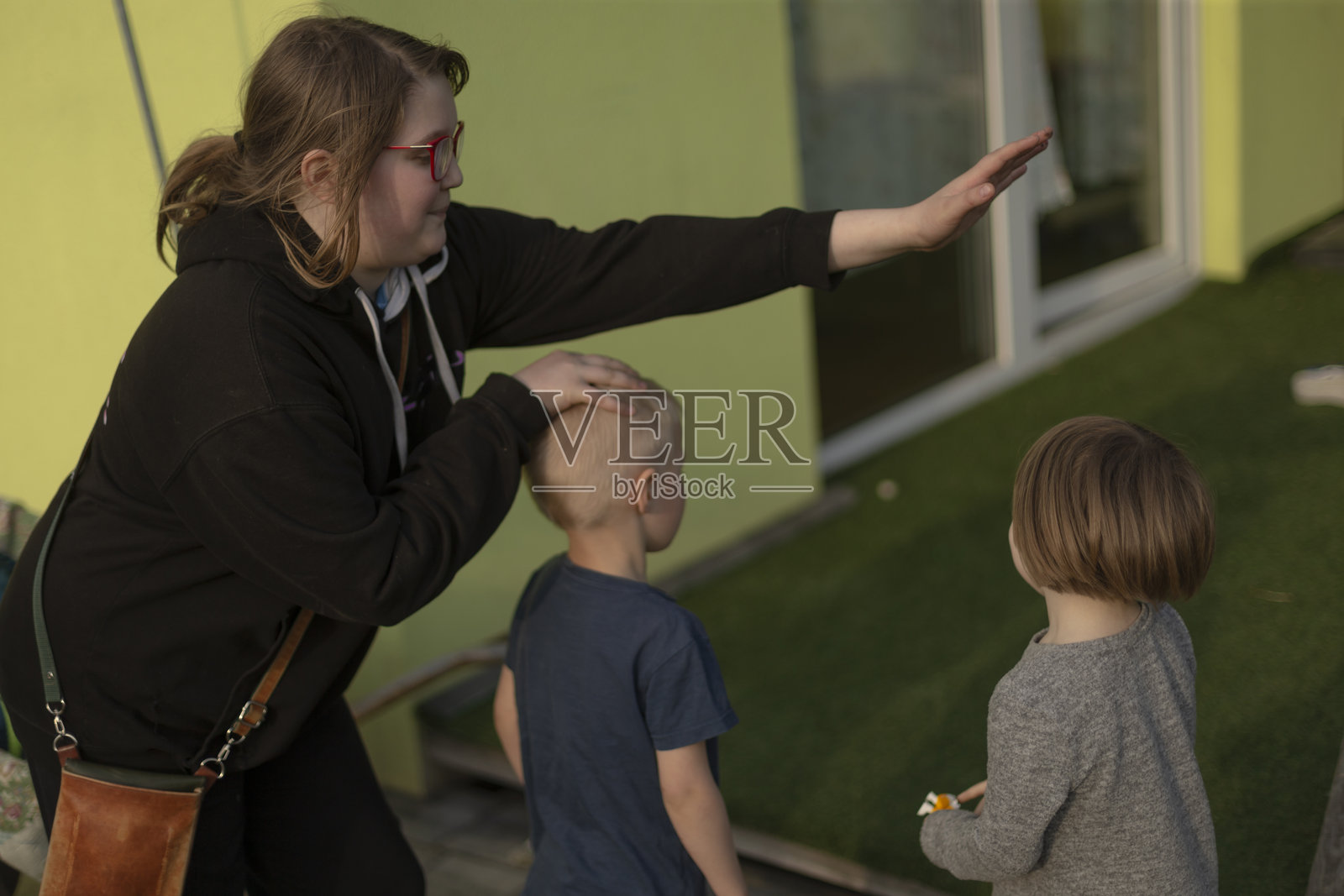 快乐的兄弟姐妹在院子里一起玩耍，记录家庭生活的自然日常瞬间照片摄影图片