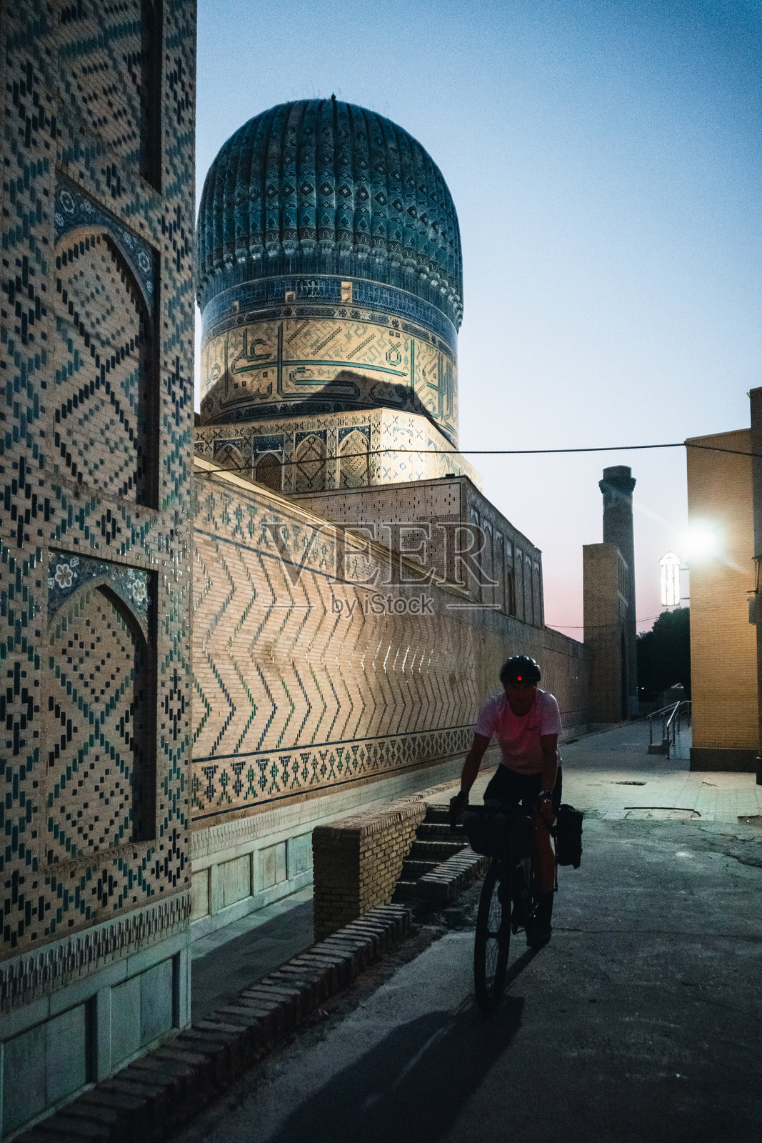 撒马尔罕的骑行背包客与传统纪念碑照片摄影图片