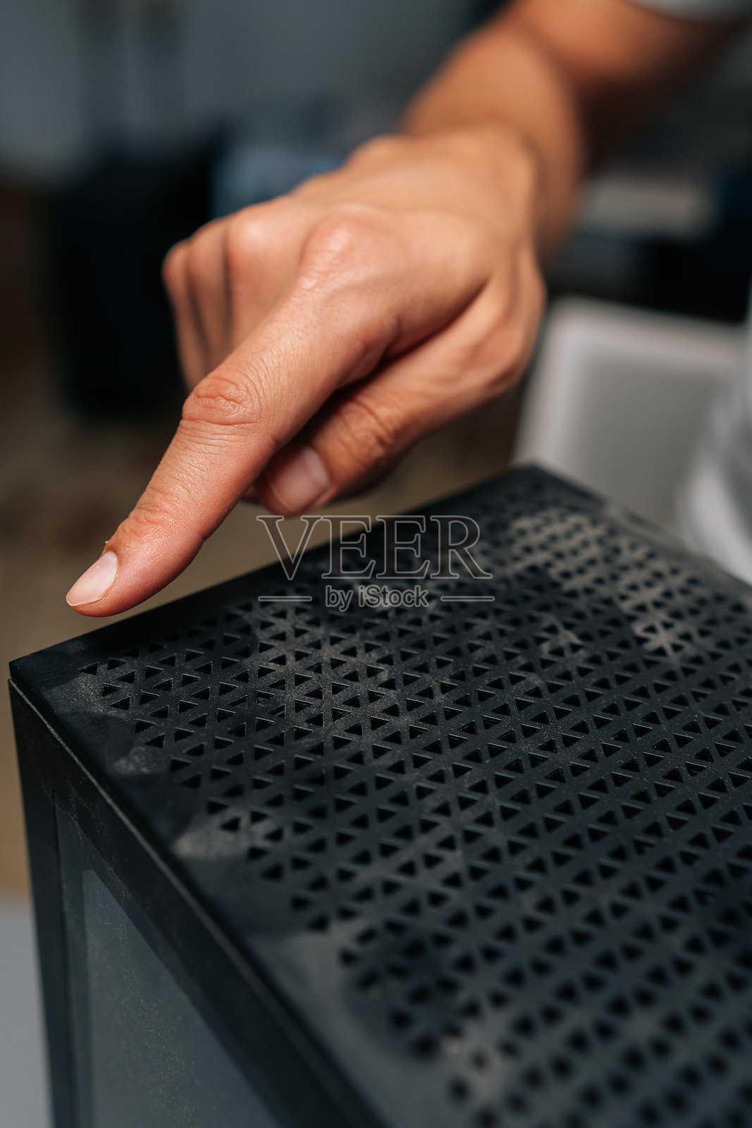 垂直裁剪的画面，技术人员手指指向电脑机箱表面的灰尘堆积，强调定期清洁和维护的重要性照片摄影图片