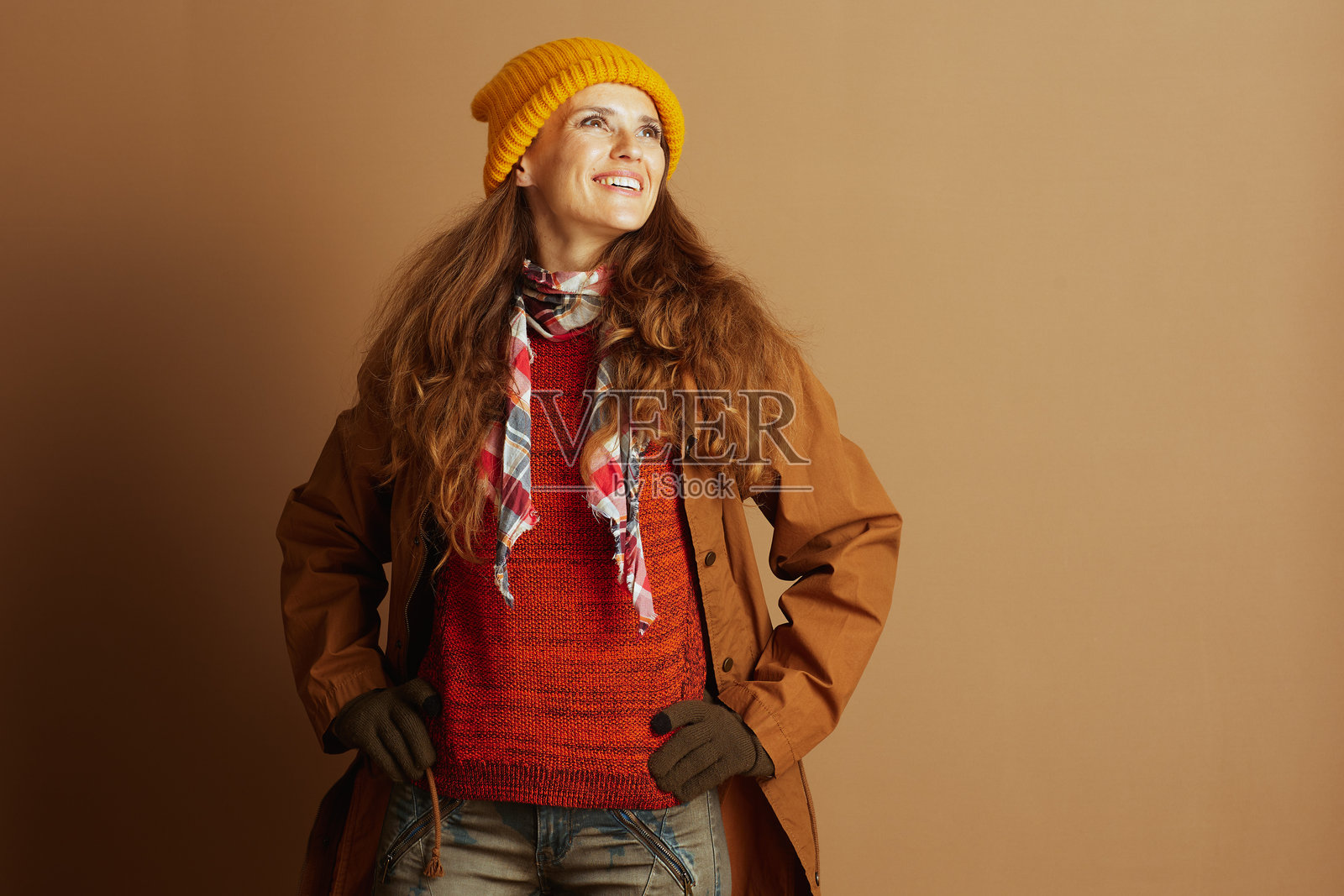 身穿秋季装备、双手叉腰的乐观女性照片摄影图片