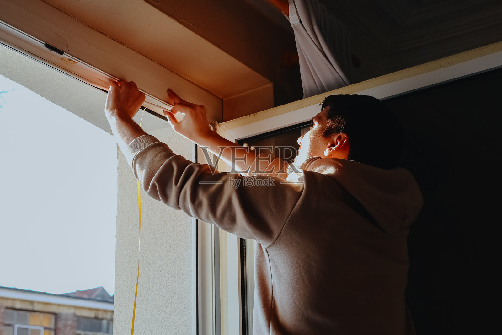 一名年轻男子正在给窗框粘贴特制的橡胶。照片摄影图片