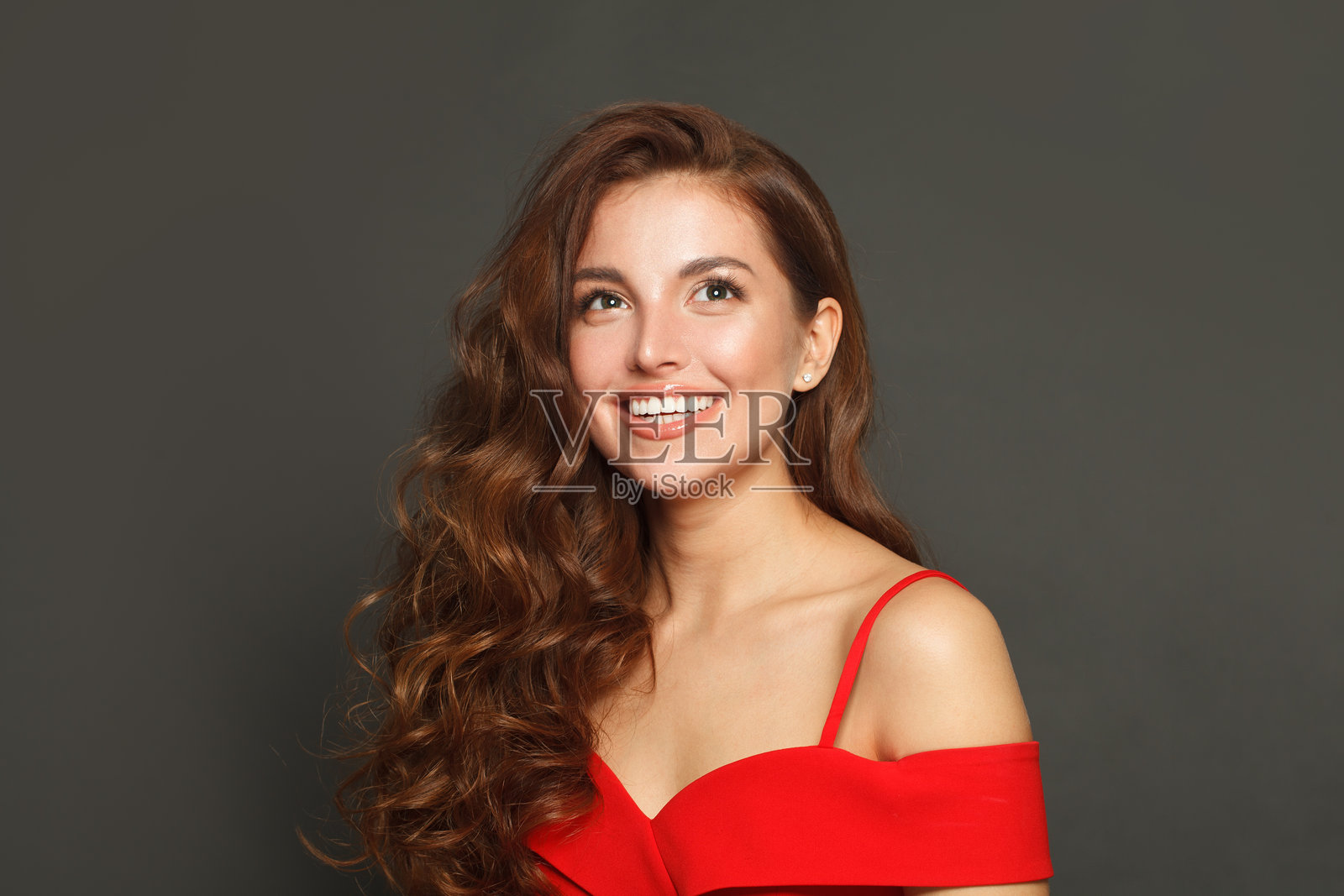 长发、化妆的可爱女子，背景为黑色。华丽的卷发女子。照片摄影图片