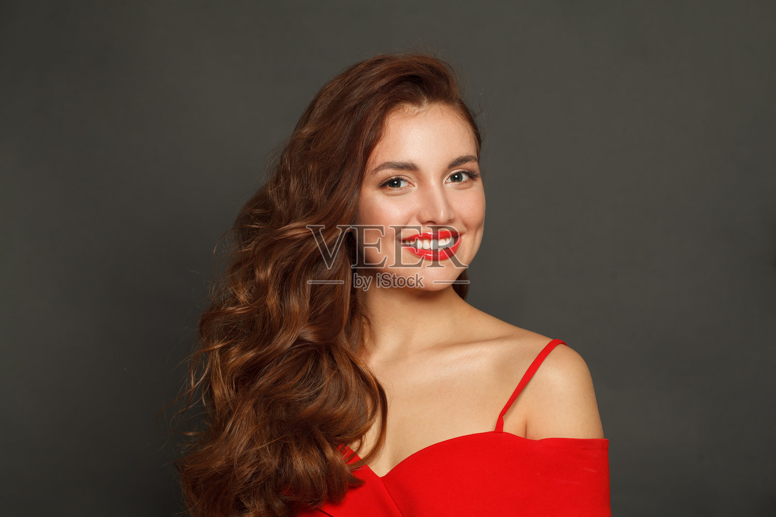 拥有光泽肌肤、波浪发型和红唇妆容的迷人时尚模特，黑色背景照片摄影图片