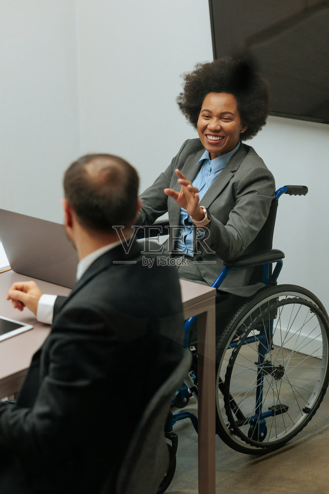 会议中，一位女办公室职员正在与同事交谈。照片摄影图片