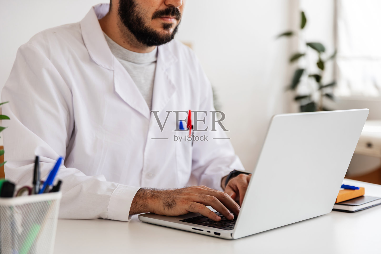 医生在笔记本电脑上工作，提供远程医疗咨询照片摄影图片