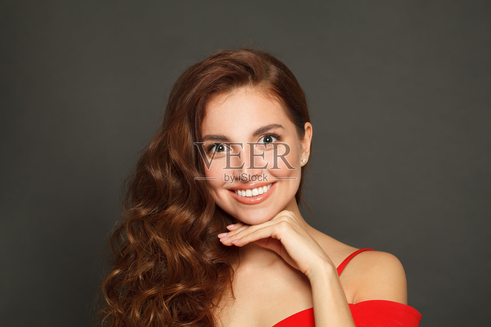 留着长发、化着妆的健康女性，背景为黑色。拥有卷发的美丽女性。照片摄影图片