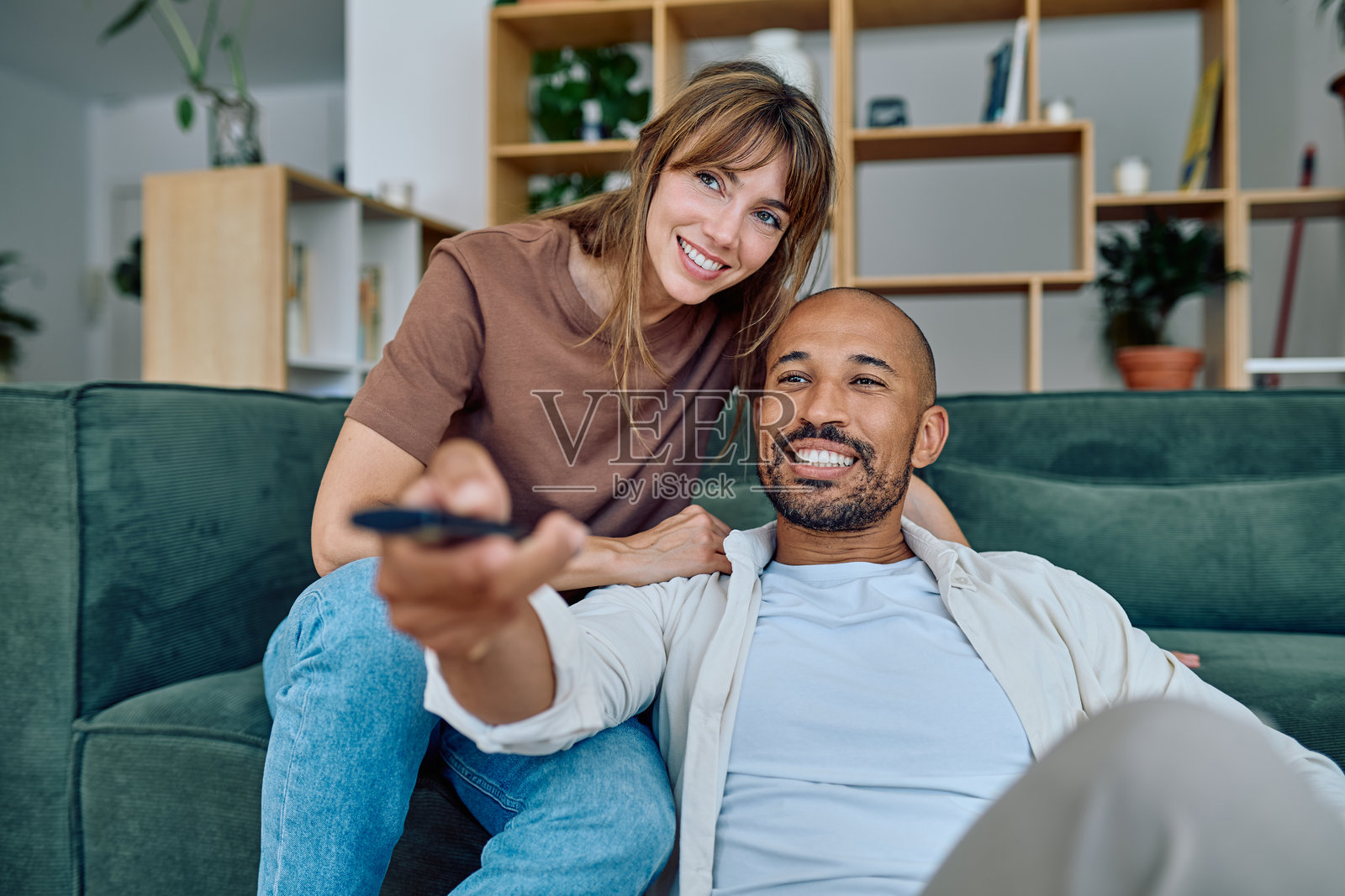 快乐的夫妇坐在客厅地板上看电视照片摄影图片