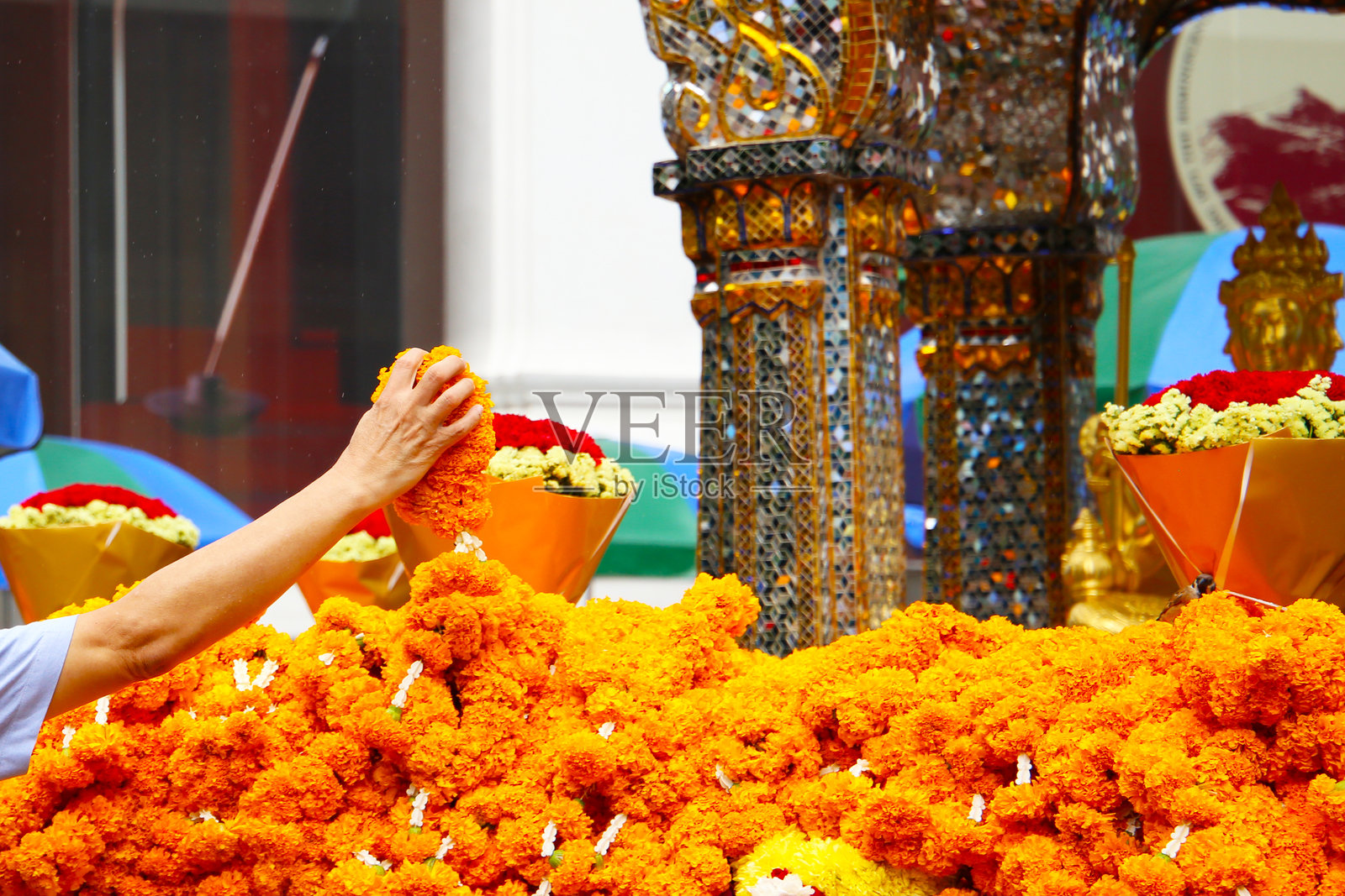泰国曼谷四面佛的祭祀万寿菊花环。照片摄影图片