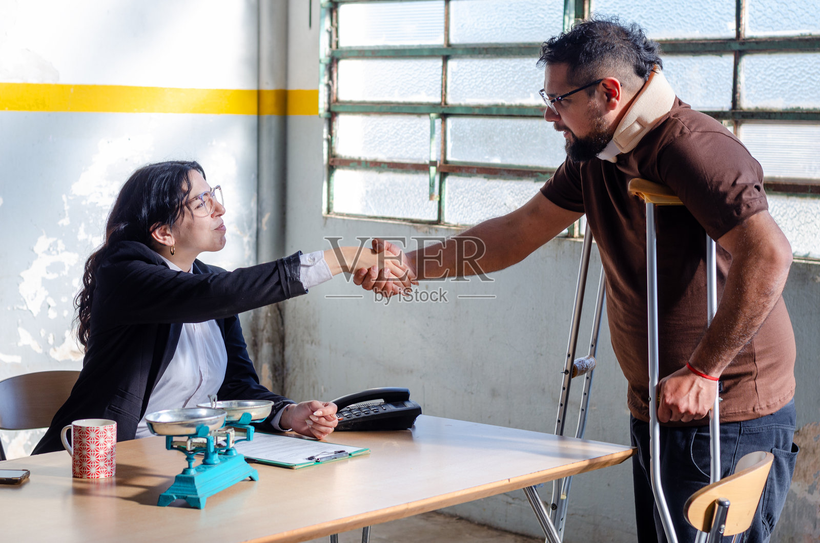 年轻的女律师或社工与意外事故受伤的男性受害者握手照片摄影图片