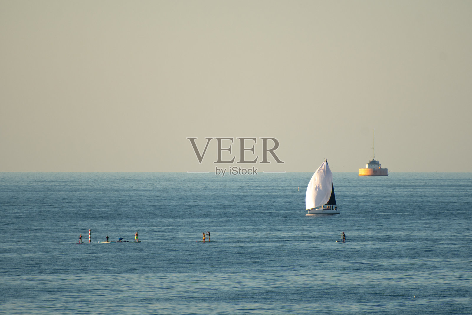 伊利湖上的桨板爱好者和帆船照片摄影图片