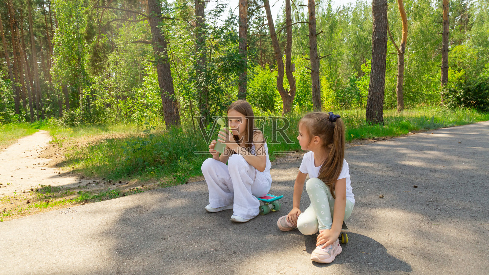 夏天，孩子们在森林里骑完滑板后休息。照片摄影图片