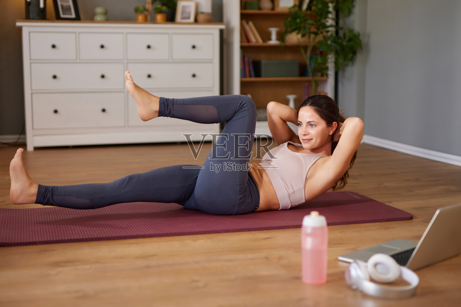 Woman exercising at home doing crunches for fitness照片摄影图片