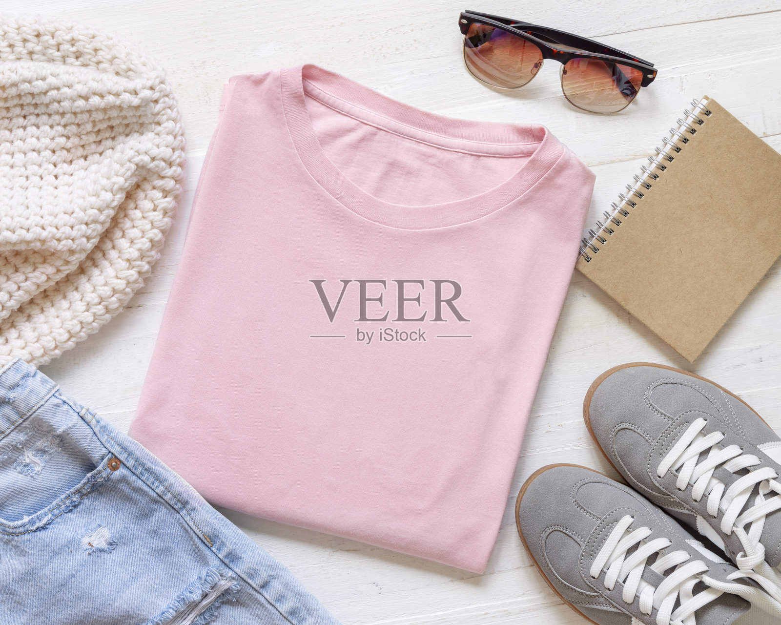 浅粉色折叠T恤空置，靠近配件摆放在白色木板上，俯视角度，男女同款模型图照片摄影图片