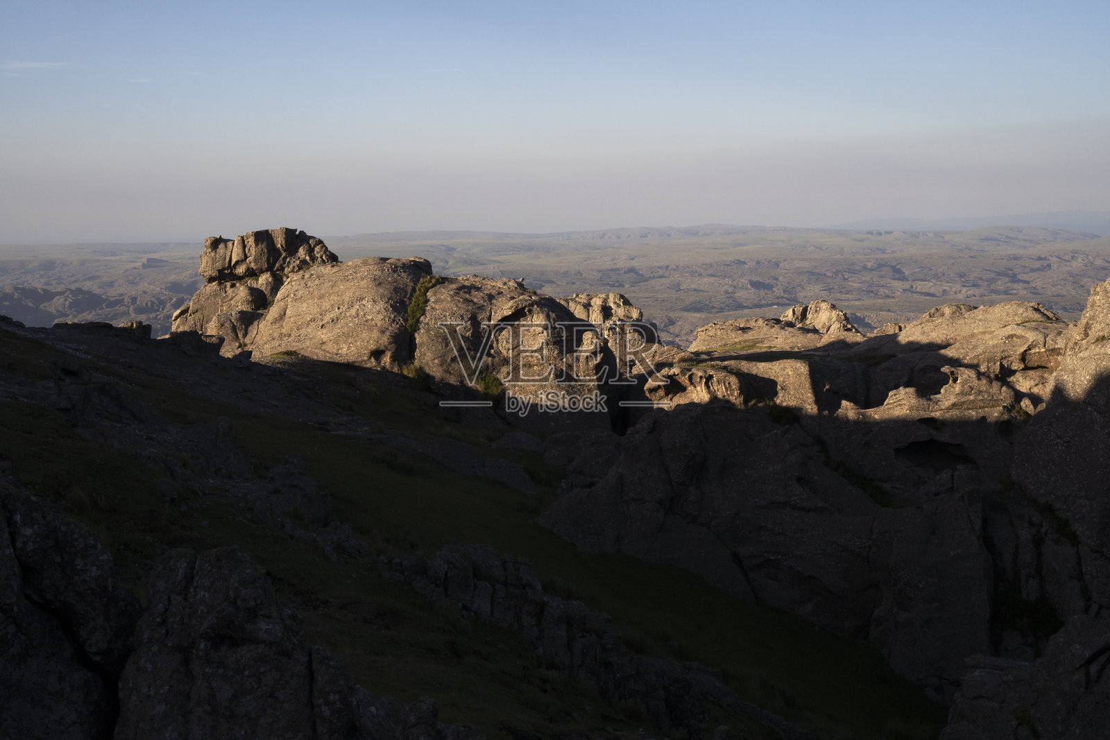 太阳躲藏，投下阴影，俯瞰山丘岩石的景象照片摄影图片