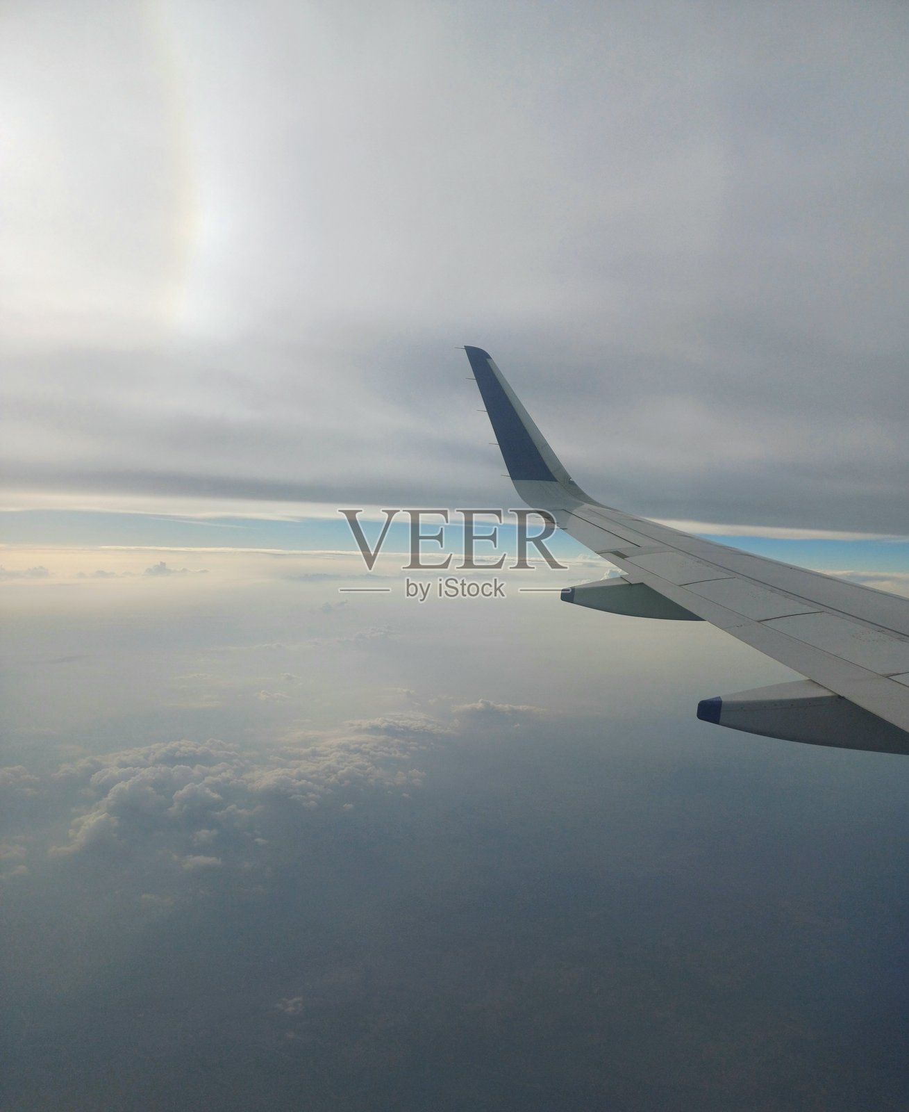 飞机窗外景象，有云层、机翼，从飞机上看到的景色。照片摄影图片