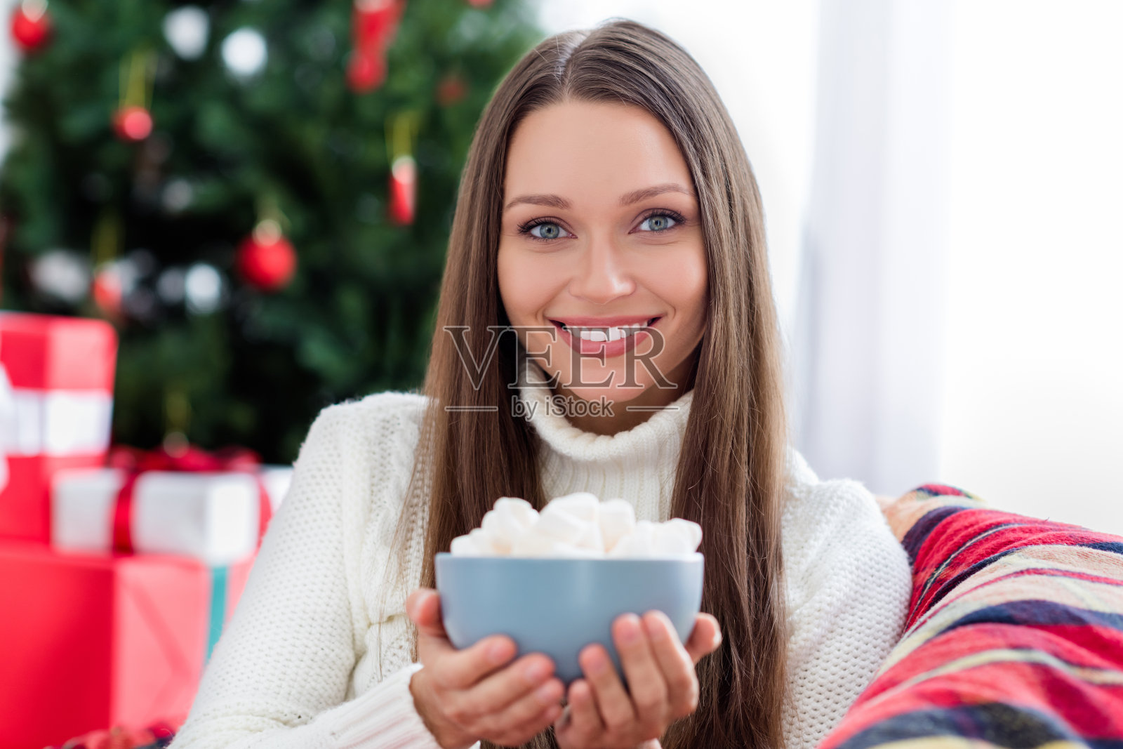 迷人的快乐女孩肖像，吃着棉花糖，在家中休息，享受闲暇时光。照片摄影图片