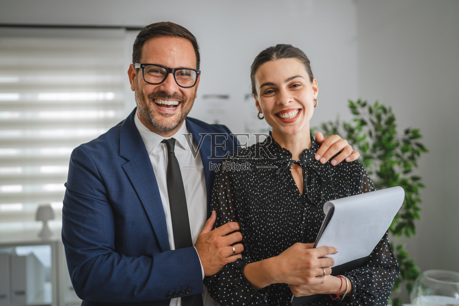 一位男商人在办公室里对着女同事微笑照片摄影图片