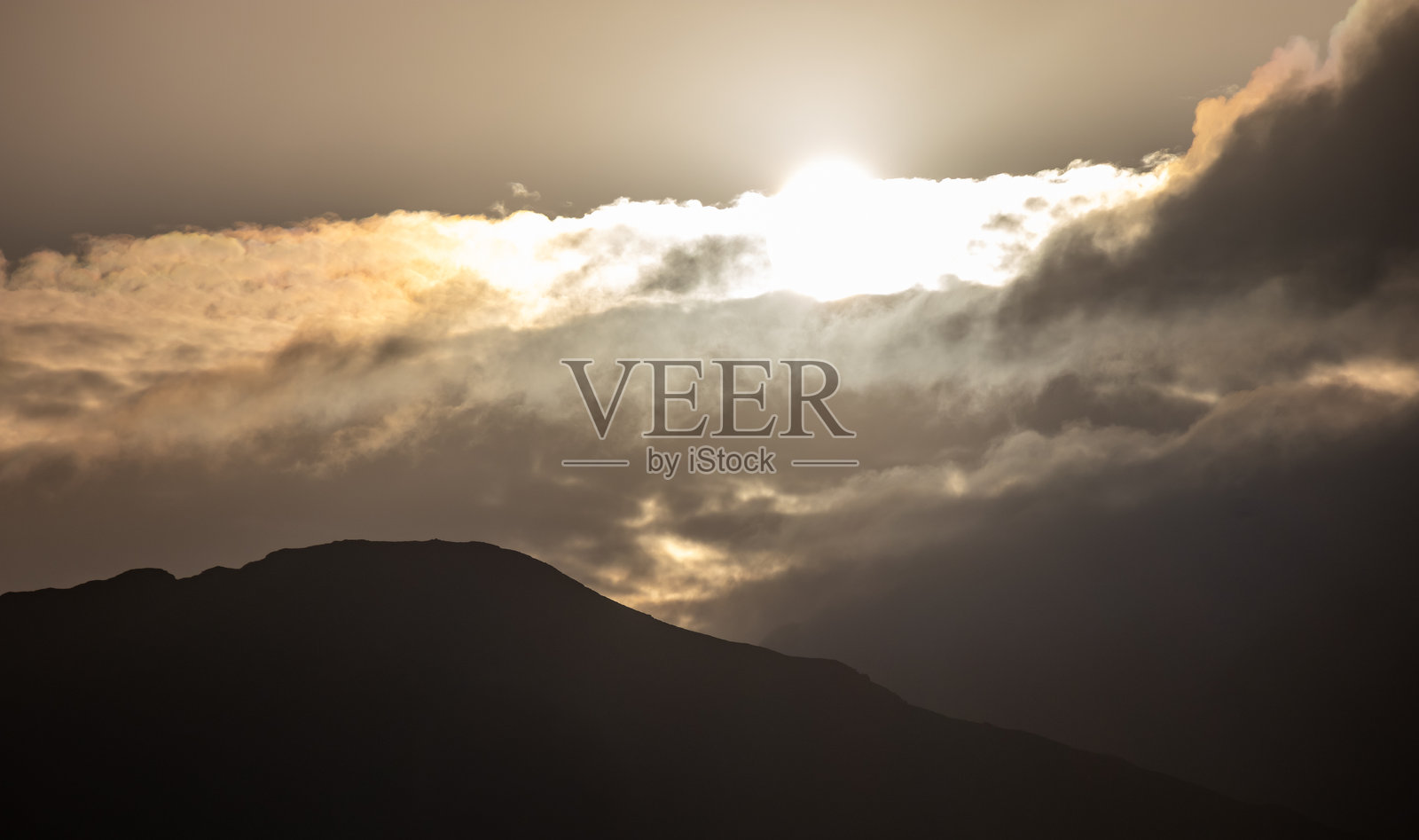 日出穿透云层， Barmouth、Gwynedd、Wales、Britain 的山脉剪影照片摄影图片