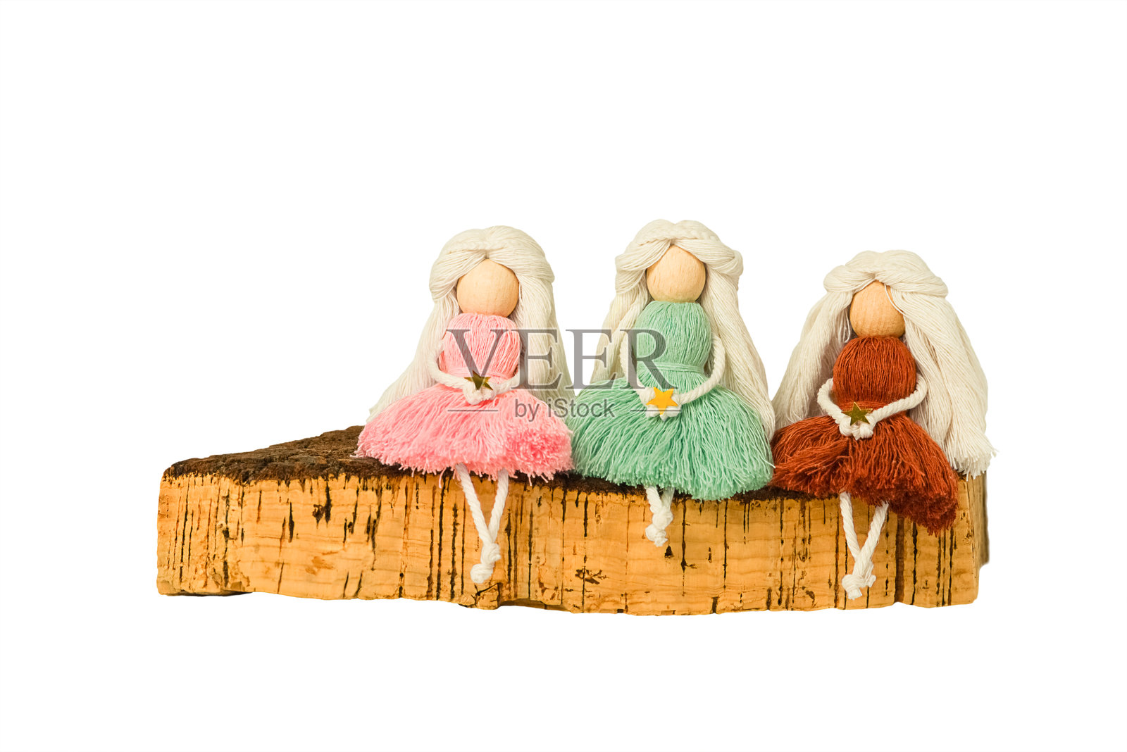 长发天使造型的孤立室内编织玩具玩偶坐在软木板上。照片摄影图片