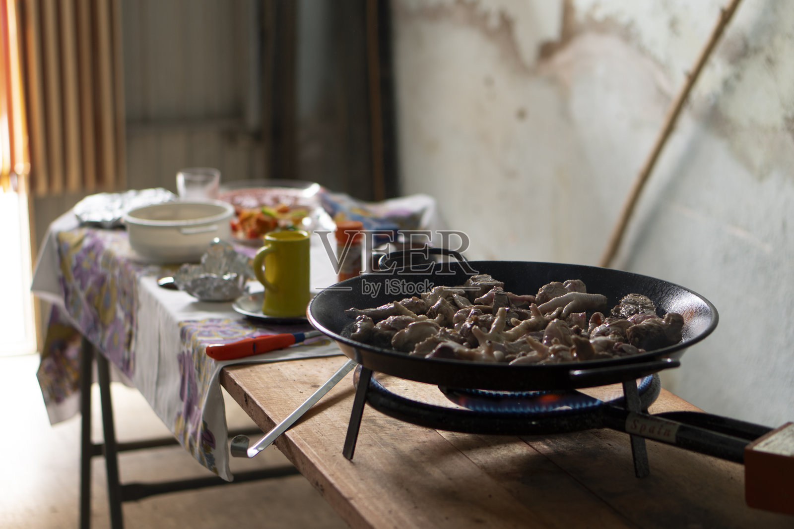 上面有一张放着黑色食物平底锅和黄色马克杯的桌子照片摄影图片