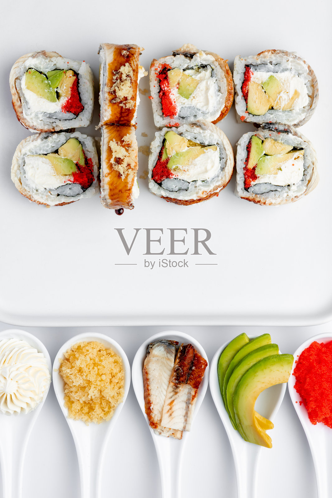 白底上孤立的鳗鱼、蟹肉和鱼子酱寿司卷照片摄影图片