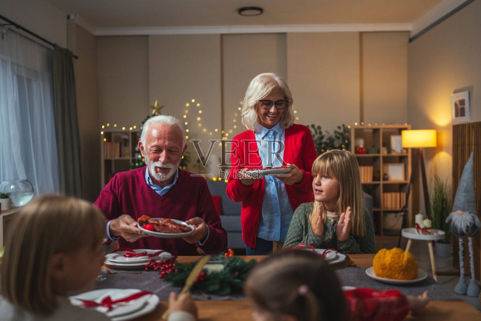 祖父母和孩子们在家一起庆祝圣诞晚餐照片摄影图片