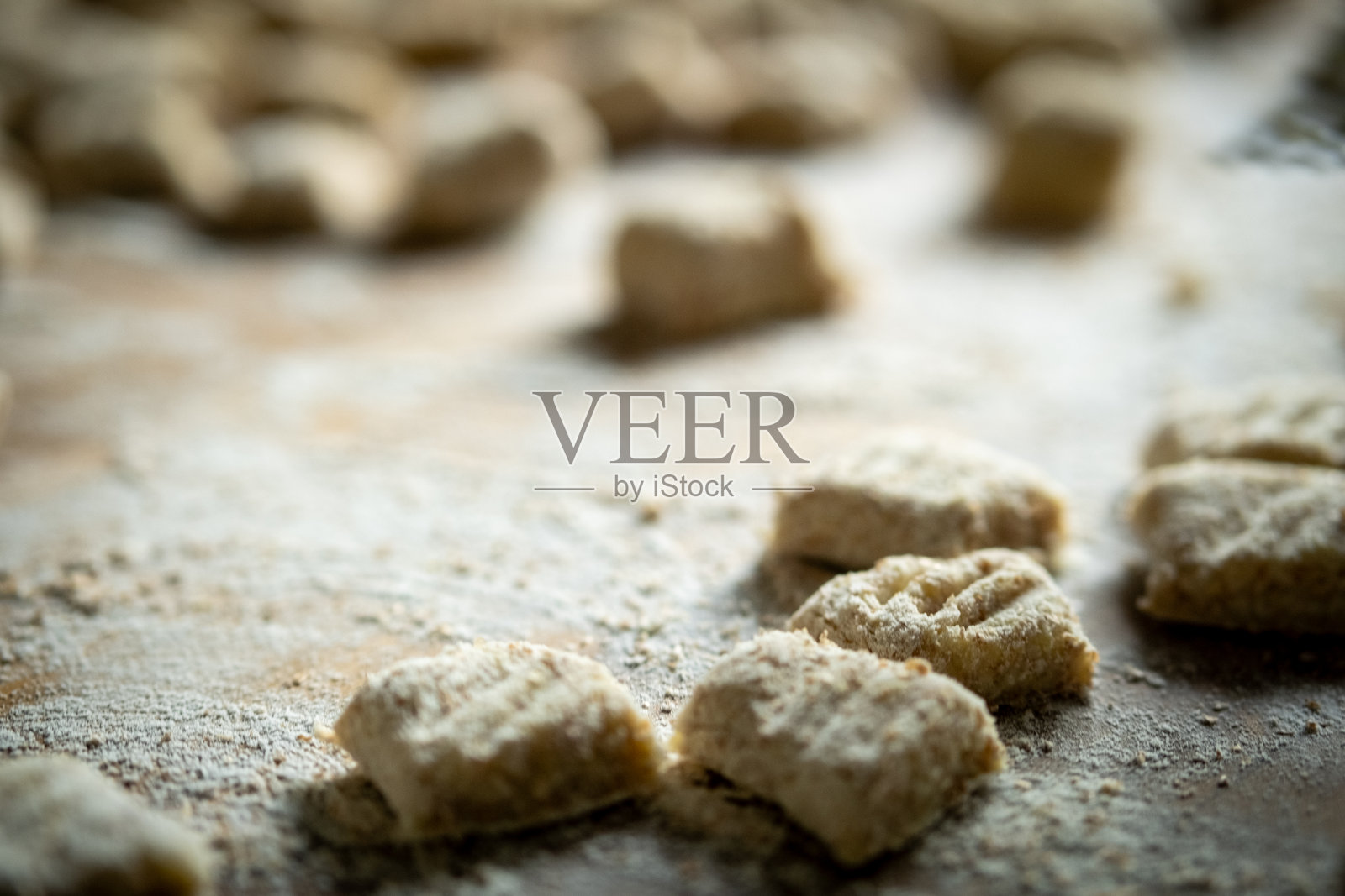 桌上摆放着生土豆团子面团，一派意大利乡村美食景象。照片摄影图片