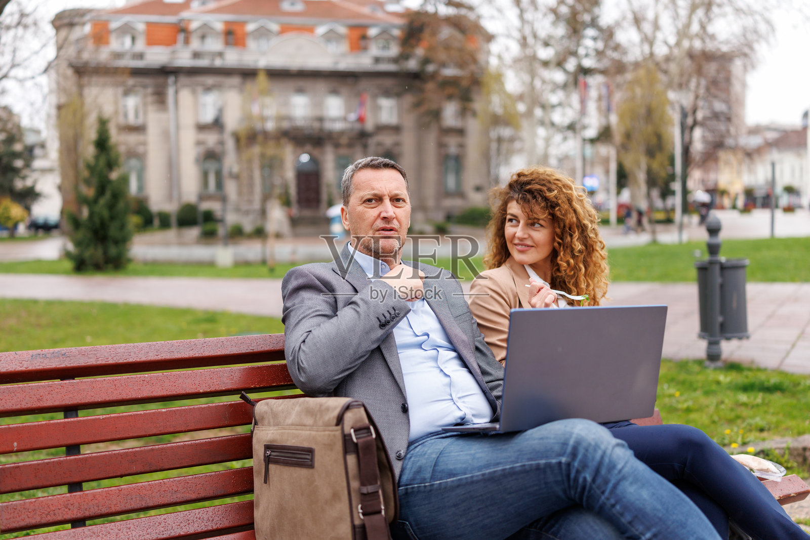 商务人士在城市长椅上使用笔记本电脑照片摄影图片