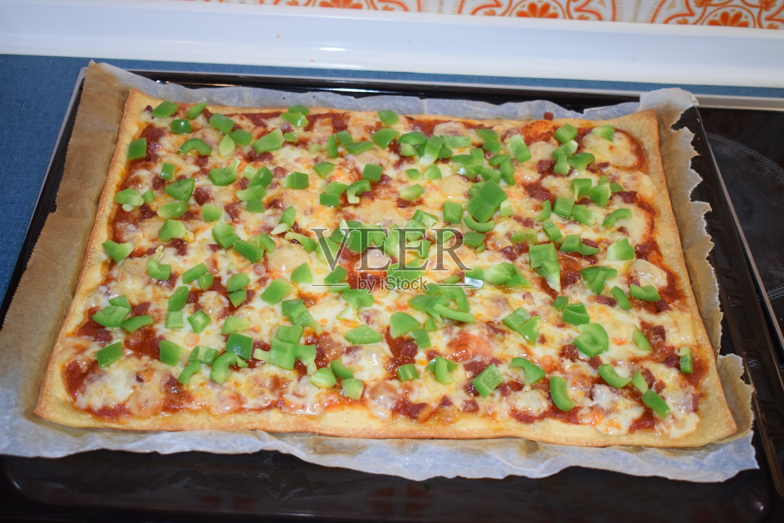 烤制并配有绿色甜椒的肉类和奶酪披萨照片摄影图片