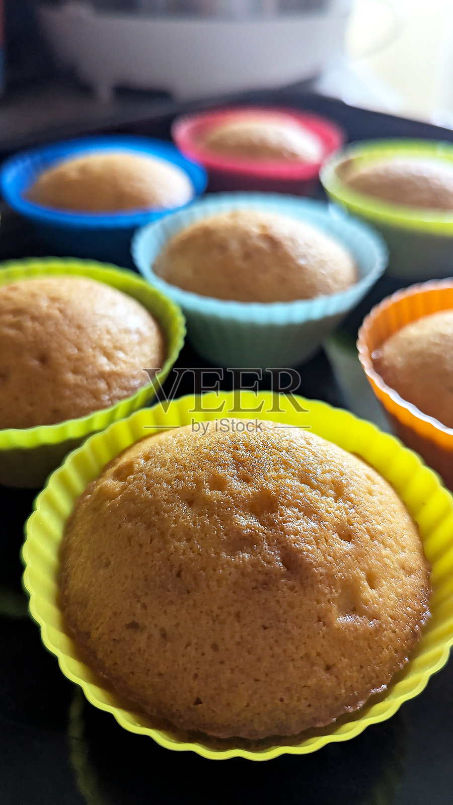 色彩鲜艳的硅胶烤杯中美味的手工纸杯蛋糕照片摄影图片