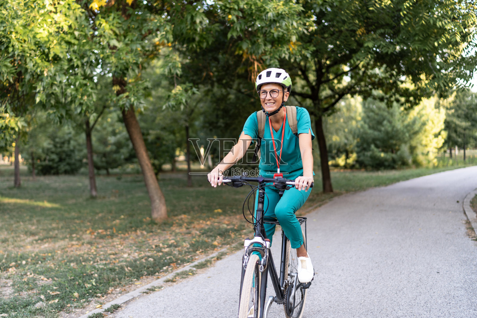 护士骑自行车在公园上班照片摄影图片