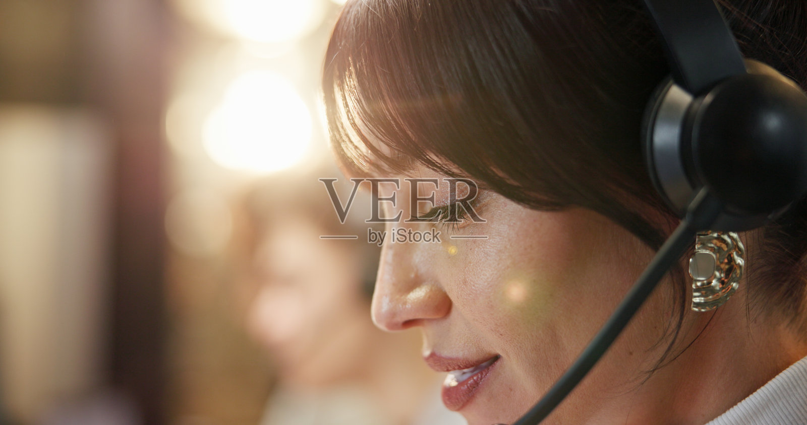 呼叫中心，特写，一位戴着耳机的女士在办公室，背景虚化，电信客服，夜晚，在线销售代理在工作空间，拥有科技、虚拟咨询和客户支持。照片摄影图片