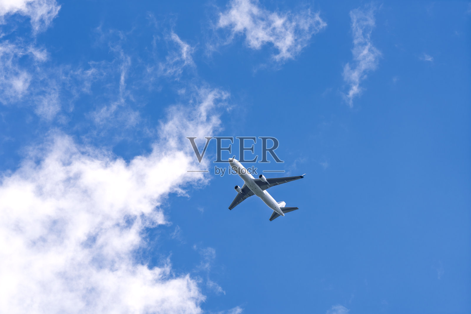 飞机在蓝天白云中飞行，旅行与航空概念照片摄影图片