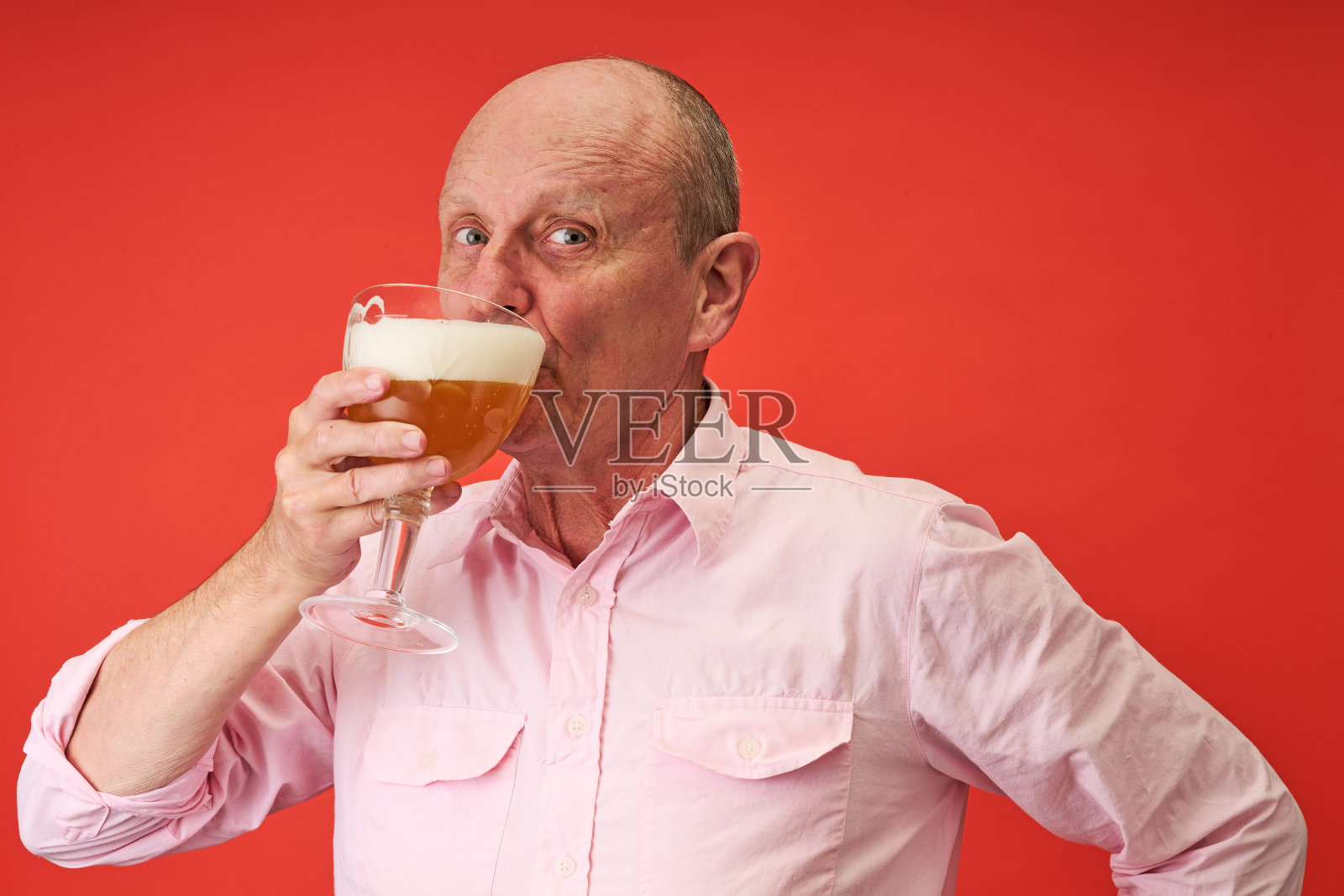 一名年长男子在影棚内特写肖像，他正饮用比利时僧侣啤酒。照片摄影图片