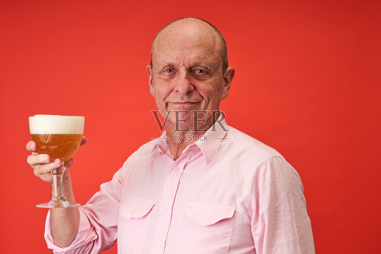 特写镜头：一位老人在影棚内饮用特拉普啤酒。照片摄影图片