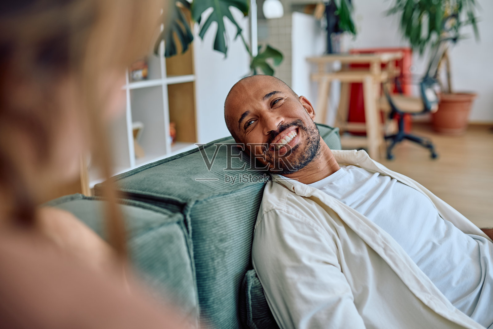 快乐的男人在家里的沙发上放松地与女人交谈照片摄影图片