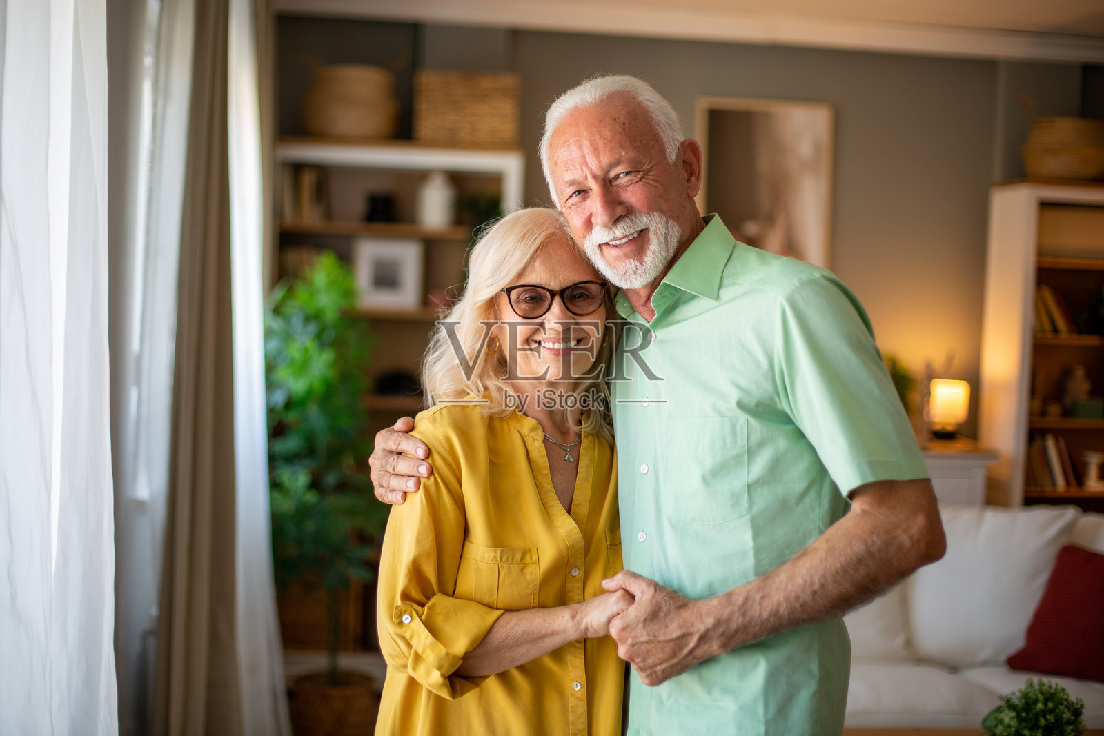 幸福的老年夫妇在家中拥抱，展现爱与连接照片摄影图片