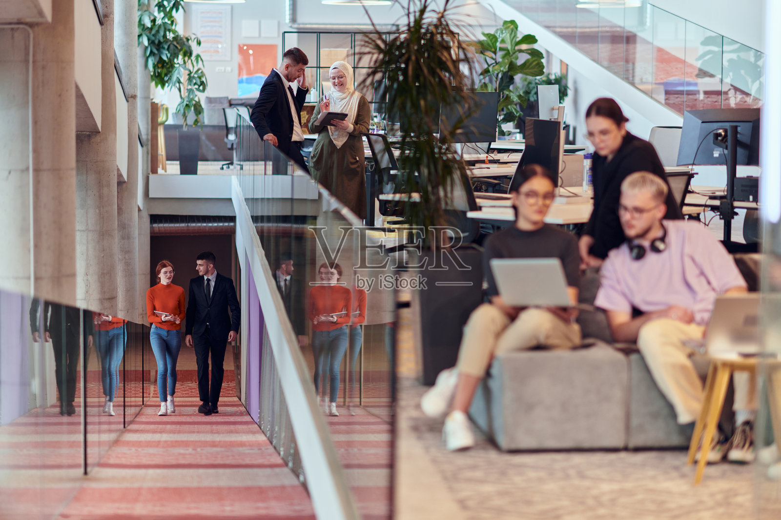 在现代创业公司办公室里，一群多元化的年轻专业人士与同事们一起协作解决各种商业问题和挑战，以激发创新和提高生产力。照片摄影图片